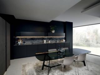 La cucina Altea di Maistri, design Alberto Minotti, è presentata nella nuova versione con l'innovativo modulo da 75 cm che garantisce una maggiore capacità di contenimento e permette di utilizzare elettrodomestici extra-large molto apprezzati dal mercato negli ultimi anni. La struttura è declinata in darkgrey e le ante sono in laccato opaco lava. Sono presenti una serie di colonne con anta rientrante realizzate in legno di frassino e una pratica luce retropensile, attivabile tramite il passaggio della mano sotto il pensile, che illumina il piano di lavoro realizzato nell'innovativo materiale Cambria. www.maistri.it  Fuorisalone, Showroom Asso-Maistri, via Larga 4, Milano