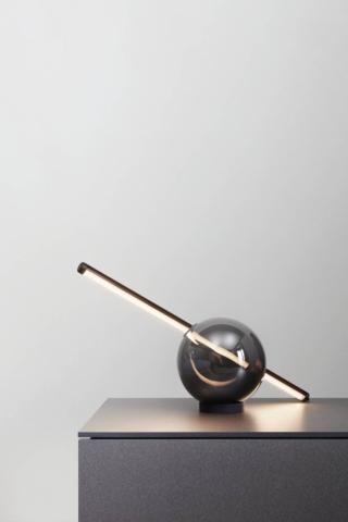 La lampada da tavolo Rugiada di Natevo, design Ilenia Viscardi, è composta da due elementi dalla forma grafica: una sfera in legno massello di frassino o in vetro soffiato in finiture diverse e da un'asta in metallo che incorpora le luci a led. www.natevo.com La lampada da tavolo Rugiada di Natevo, design Ilenia Viscardi, è composta da due elementi dalla forma grafica: una sfera in legno massello di frassino o in vetro soffiato in finiture diverse e da un'asta in metallo che incorpora le luci a led. www.natevo.com