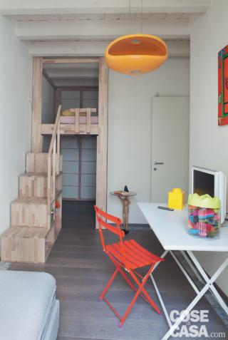 Nella camera dei ragazzi il letto a soppalco in legno di faggio adattato su misura è del programma Rising di Cinius. Il lampadario arancione è il modello O-Space di Foscarini. Tavolino con piano in vetro Pinocchio di Valsecchi.