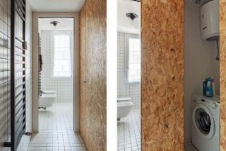 Antibagno del bilocale, scaldasalviette nero, pannelli in OBS, lavanderia nascosta, lavatrice, scaldabagno, piastrelle bianche in piccolo formato, fughe nere, bagno, sanitari sospesi, plafoniera