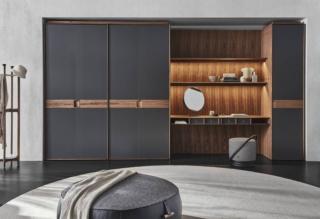 Ha le ante a battente rivestite in pregiato cuoietto grigio scuro il grande armadio Mycloset di Porada che accoglie al suo interno un angolo studio/toeletta. Dettagli,  interni e maniglie sono realizzati in pregiato noce Canaletto. Inoltre è completamente personalizzabile per soddisfare qualsiasi esigenza. Prezzo su richiesta. www.porada.it