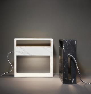 L’edizione speciale T (perché solo da tavolo) della lampada da tavolo NoName (design Giuseppe e Lazzaro Raboni, Marco Zanuso jr) di Pollice Illuminazione viene proposta in sei nuove finiture, di cui tre di marmo calacatta, marquinia o zebrino striato (e altrettante di legno di olmo, wengé o noce), con sorgente luminosa posizionata internamente al corpo, al fine di esaltarne la forma scultorea. Ispirata ai Quadri di Luce di Gio Ponti, è un oggetto luminoso frutto del dialogo tra designer e artigiani eredi della tradizione della lavorazione dei materiali pregiati. Il modulo quadrato è ripartito da una fascia orizzontale asimmetrica, che separa la parte inferiore con led “dim to warm” da quella superiore, solcata da un taglio di luce. Il cavo di alimentazione, rivestito con tessuto in diversi colori, diventa elemento decorativo. Prezzo 2.990 euro. www.polliceilluminazione.it