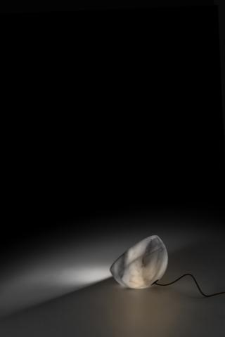 La lampada Tsuki (design Naoto Fukasawa) di DePadova, sia da tavolo sia da appoggio a terra, si distingue per la semplicità del disegno, impreziosito dalla lavorazione di un blocco di marmo calacatta. La mezza sfera materica (disponibile anche di legno massello di cedro libanese finito con vernice trasparente o di cemento grigio chiaro), di ispirazione quasi astrale, nasconde un diffusore di vetro trasparente con semi-copertura di alluminio lucido per la sorgente luminosa a led. Discreta e funzionale, vive da sola ma può anche essere posizionata in serie, per creare suggestivi e ritmati coni di luce. Prezzo su richiesta. www.depadova.com