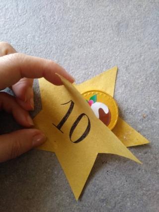  
Poggiate la moneta di cioccolato su una stella e incollateci sopra l’altra stella con la colla stick.