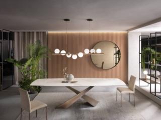 Un piano a botte allungabile per il tavolo Living di Riflessi realizzato in ceramica Calacatta Oro lucido con angoli smussati. La base è caratterizzata da due gambe inclinate e sovrapposte fra loro in maniera asimmetrica, realizzate in metallo con finitura Ottone spazzolato a mano. Misura L 145/225 x P 90 x H 75 cm. Prezzo 5.367 euro  www.riflessi.it