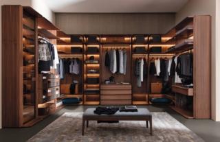 Ha una forma a golfo la cabina armadio componibile Mysuite di Porada caratterizzata da una struttura in noce canaletta con i profili in legno massello e un inserto in metallo finitura peltro. È completamente personalizzabile con una serie di accessori in cristallo fumé, legno e con rivestimento in cuoietto. I ripiani possono essere dotati di illuminazione a LED nella parte inferiore. Prezzo su richiesta. www.porada.it