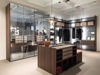 Grande e organizzata la cabina angolare del Sistema Freedhome di Caccaro composta da una serie di moduli, profilati dai montanti a vista nella finitura Titanio Brunito, che accolgono ripiani, cassettiere, portascarpe, portapantaloni... Sono presenti una serie di led annegati nello spessore dei montanti che valorizzano lo schienale in piqué. Una sezione è chiusa da ante in vetro Silver Stop-sol; la struttura è in Easy Eucalipto. Misura L 552,5/260 x P 62,7/57,5 x H 263,6 cm. Prezzo da 14.000 euro + IVA. www.caccaro.com