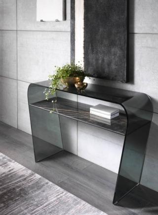 Un pezzo design, elegante e ricercato, la consolle Saphiria di Riflessi: è completamente realizzata in pregiato cristallo curvato fumé che la rende leggera e permette di ambientarla praticamente ovunque. È impreziosita da un ripiano in ceramica scura ad imitazione del marmo con una venatura che si trasforma in elemento decorativo. Misura L 120 x P 48/198 x H 75 cm. Prezzo 1.180 euro. www.riflessi.it Un pezzo design, elegante e ricercato, la consolle Saphiria di Riflessi: è completamente realizzata in pregiato cristallo curvato fumé che la rende leggera e permette di ambientarla praticamente ovunque. È impreziosita da un ripiano in ceramica scura ad imitazione del marmo con una venatura che si trasforma in elemento decorativo. Misura L 120 x P 48/198 x H 75 cm. Prezzo 1.180 euro. www.riflessi.it