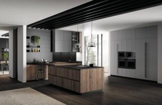 Una lunga e importante maniglia 1320 brunita godronata per le colonne laccate poro aperto grigio selenio della composizione dal design moderno Asia di Arredo3. L'isola centrale invece ha le ante lisce, con gola, realizzate in impiallacciato travi rovere safari e il top in resistente quarzo venato dark. La boiserie in PET (materiale plastico PVC free) nero opaco è dotata di pratici vassoi; il pensile vetrinetta Teca ha la cornice brunito.  Prezzo su richiesta. www.arredo3.it Una lunga e importante maniglia 1320 brunita godronata per le colonne laccate poro aperto grigio selenio della composizione dal design moderno Asia di Arredo3. L'isola centrale invece ha le ante lisce, con gola, realizzate in impiallacciato travi rovere safari e il top in resistente quarzo venato dark. La boiserie in PET (materiale plastico PVC free) nero opaco è dotata di pratici vassoi; il pensile vetrinetta Teca ha la cornice brunito.  Prezzo su richiesta. www.arredo3.it