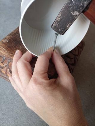 Con un chiodo e un martello, forate il barattolo in due punti