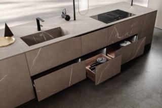 Stile minimalista per il modello Elementi di Snaidero che si articola intorno all'isola attrezzata con il lavello integrato e il piano cottura ad induzione: le ante lisce, con il profilo maniglia integrato  dalla singolare sagomatura inclinata dell’anta stessa per permetterne l’apertura, sono caratterizzate da una sottile venatura effetto pietra. Un modulo base da 60 cm con anta battente in nobilitato, prezzo 303 euro. www.snaidero.it Stile minimalista per il modello Elementi di Snaidero che si articola intorno all'isola attrezzata con il lavello integrato e il piano cottura ad induzione: le ante lisce, con il profilo maniglia integrato  dalla singolare sagomatura inclinata dell’anta stessa per permetterne l’apertura, sono caratterizzate da una sottile venatura effetto pietra. Un modulo base da 60 cm con anta battente in nobilitato, prezzo 303 euro. www.snaidero.it