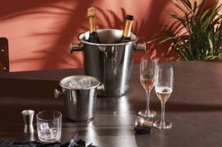 Permette di mantenere alla giusta temperatura ben due bottiglie di champagne o di vino per una lunghissima serata il rinfrescatore 5052 di Alessi; è completamente realizzato in acciaio inossidabile 18/10 con la superficie esterna lucida e quella interna satinata. È dotato di due manici che consentono di spostarlo agevolmente. Misura Ø 21 x H 23 cm. Prezzo 215 euro. Il secchiello per il ghiaccio coordinato 5051 misura Ø 14,50 x H 14 cm. Prezzo 129 euro. www.alessi.com