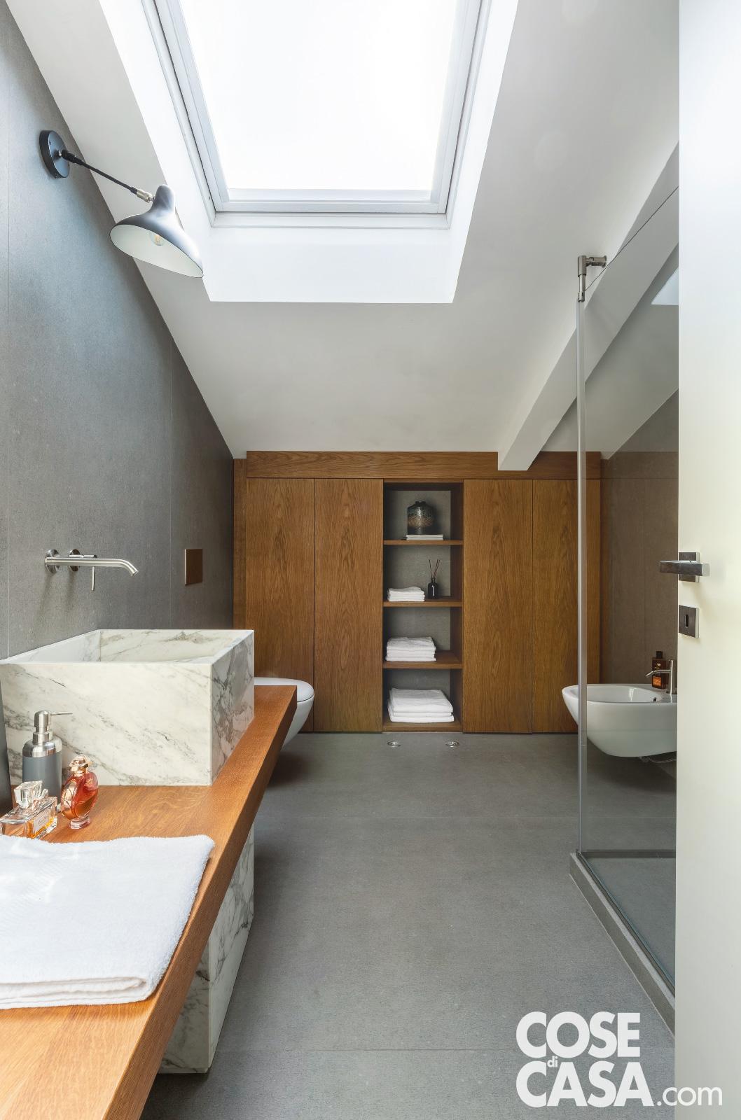 bagno nel sottotetto con mobile, piano in legno e lavabo da appoggio bagno nel sottotetto con mobile, piano in legno e lavabo da appoggio