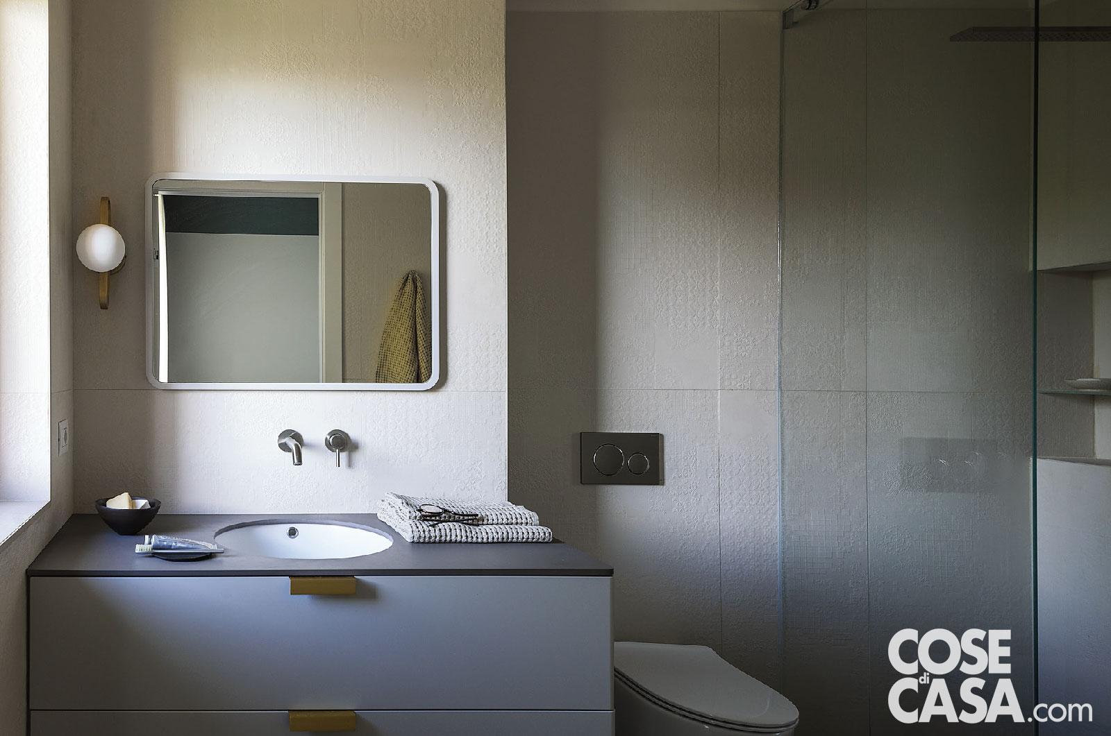 bagno, mobile con lavabo tondo incassato, rubinetteria a parete, specchio rettangolare, asciugamani, sanitari, rivestimento in rilievo, doccia in muratura, pannello in vetro, nicchia con ripiani bagno, mobile con lavabo tondo incassato, rubinetteria a parete, specchio rettangolare, asciugamani, sanitari, rivestimento in rilievo, doccia in muratura, pannello in vetro, nicchia con ripiani