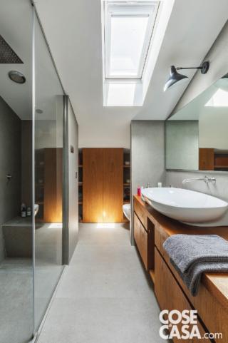 Nel bagno della zona notte, sistemato tra la camera matrimoniale e le stanze dei ragazzi, due spalle in muratura a destra e a sinistra schermano i sanitari (Spin di Ceramica
Flaminia) rispetto alla zona lavabo e al box doccia walk-in, rendendoli così invisibili dall'ingresso. Sul mobile in rovere tinto, il lavabo ovale è Nuda 95 di Ceramica Flaminia; miscelatore a parete di Cea. L'applique è di Serge Mouille. Il pavimento è in Kerlite di Cotto D'Este spessore 5 mm. Piatto doccia incassato a filo pavimento di Wedi; di Viabizzuno le luci segnapasso a pavimento. Nel bagno della zona notte, sistemato tra la camera matrimoniale e le stanze dei ragazzi, due spalle in muratura a destra e a sinistra schermano i sanitari (Spin di Ceramica
Flaminia) rispetto alla zona lavabo e al box doccia walk-in, rendendoli così invisibili dall'ingresso. Sul mobile in rovere tinto, il lavabo ovale è Nuda 95 di Ceramica Flaminia; miscelatore a parete di Cea. L'applique è di Serge Mouille. Il pavimento è in Kerlite di Cotto D'Este spessore 5 mm. Piatto doccia incassato a filo pavimento di Wedi; di Viabizzuno le luci segnapasso a pavimento.