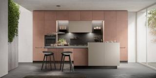 La nuova cucina Unica di Lube unisce un design d'eccezione e materiali ecosostenibili: è infatti certificata GREENGUARD Gold, che assicura che tutte le strutture dei prodotti del Gruppo sono conformi agli standard più rigorosi in termini di livelli di emissione di composti organici volatili (COV) emessi da mobili, superfici e vernice oltre ad altre sostanze chimiche nocive negli ambienti interni. Le basi e le colonne con una colorazione soft sono nella finitura Pietra Fulvus; i pensili e l'elemento in aggetto per l'isola in Ecru. Il top in Fenix Fumo, le maniglie e lo zoccolo nella finitura Silver Dark scandiscono la composizione. Il mobile Break, che completa l'isola, aumenta lo spazio contenitivo a disposizione e consente di alloggiare utensili e piante aromatiche nella vaschetta superiore. www.cucinelube.it