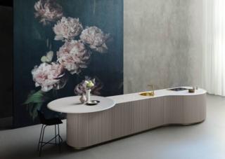 Il progetto Tangram di Cesar è composto da cinque elementi curvi che si possono unire a piacere ad altri con anta dritta per dare vita ad un'isola con una geometria inconsueta, addossata a parete o in grado di abbracciare gli angoli. Le ante sono rese speciali da un dettaglio particolare come la finitura 3D composta da una sequenza di fresature verticali che creano un pattern tridimensionale irregolare, ma estremamente decorativo. Il bordo del piano in pietra con la lavorazione Macaron eseguita a mano seguendo un'antica tecnica richiama le tradizionali scanalature salvagocce. Le finiture disponibili sono i laccati seta, strutturati, effetto metallico Anodyc. www.cesar.it