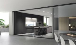 Il modello della collezione AL 32 di Arrex ha un design minimale e rigoroso, sottolineato dalle ante lisce in vetro nero opaco dell'armadiatura che incornicia la nicchia con la zona lavello. Le colonne a tutta altezza consentono di sfruttare al meglio lo spazio e aumentano la capacità di contenimento. L'isola centrale, dotata di un tavolo con il sostegno in vetro trasparente, ha le basi con le ante, con il telaio in alluminio riciclabile nella finitura antracite, realizzate in HPL stratificato nella finitura Cemento. www.arrex.it