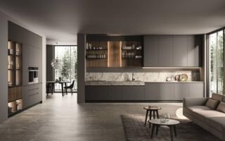 La composizione lineare Traccia di Febal Casa è interpretata come una vera e propria estensione del living ed è caratterizzata da una palette di colori sobri e eleganti, interrotta dal top e dallo schienale Palladio. Le ante lisce, dei pensili e delle basi, nella colorazione Grigio titanio sono illuminate dalla boiserie nella finitura Eucalipto con mensole in metallo e luci integrate, disposte strategicamente, per creare movimento e amplificare i volumi. Il top Monos, con uno spessore alto, definisce la zona operativa.  www.febalcasa.com