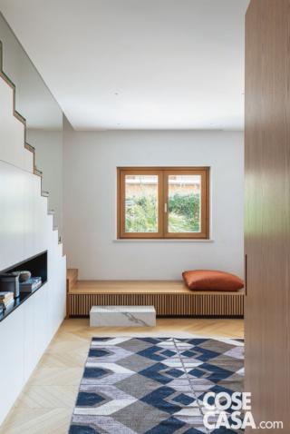 scala, contenitori nel sottoscala in laccato bianco, nicchia, finestra in legno, panchetta in legno, gradino in marmo, tappeto con decori geometrici, cuscino rosso scala, contenitori nel sottoscala in laccato bianco, nicchia, finestra in legno, panchetta in legno, gradino in marmo, tappeto con decori geometrici, cuscino rosso