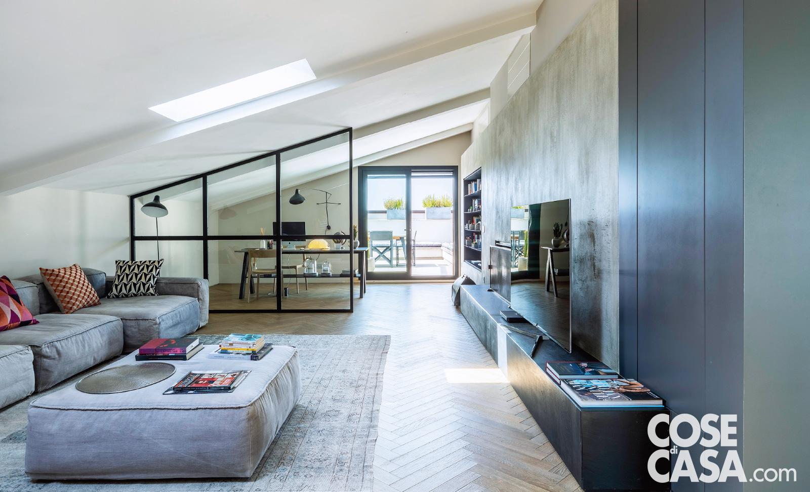 La zona dello studio e il soggiorno, all'interno dell'open space, sono raccordati dalla parete attrezzata su disegno che corre lungo il lato opposto.Questa struttura ha finitura grigio spatolato effetto cemento; nel tamponamento superiore in cartongesso sono integrate le bocchette dell'impianto di climatizzazione canalizzato. Lucernari di Velux. Nell'angolo tra il divano e la vetrata divisoria, la lampada a stelo è di Serge Mouille. La zona dello studio e il soggiorno, all'interno dell'open space, sono raccordati dalla parete attrezzata su disegno che corre lungo il lato opposto.Questa struttura ha finitura grigio spatolato effetto cemento; nel tamponamento superiore in cartongesso sono integrate le bocchette dell'impianto di climatizzazione canalizzato. Lucernari di Velux. Nell'angolo tra il divano e la vetrata divisoria, la lampada a stelo è di Serge Mouille.