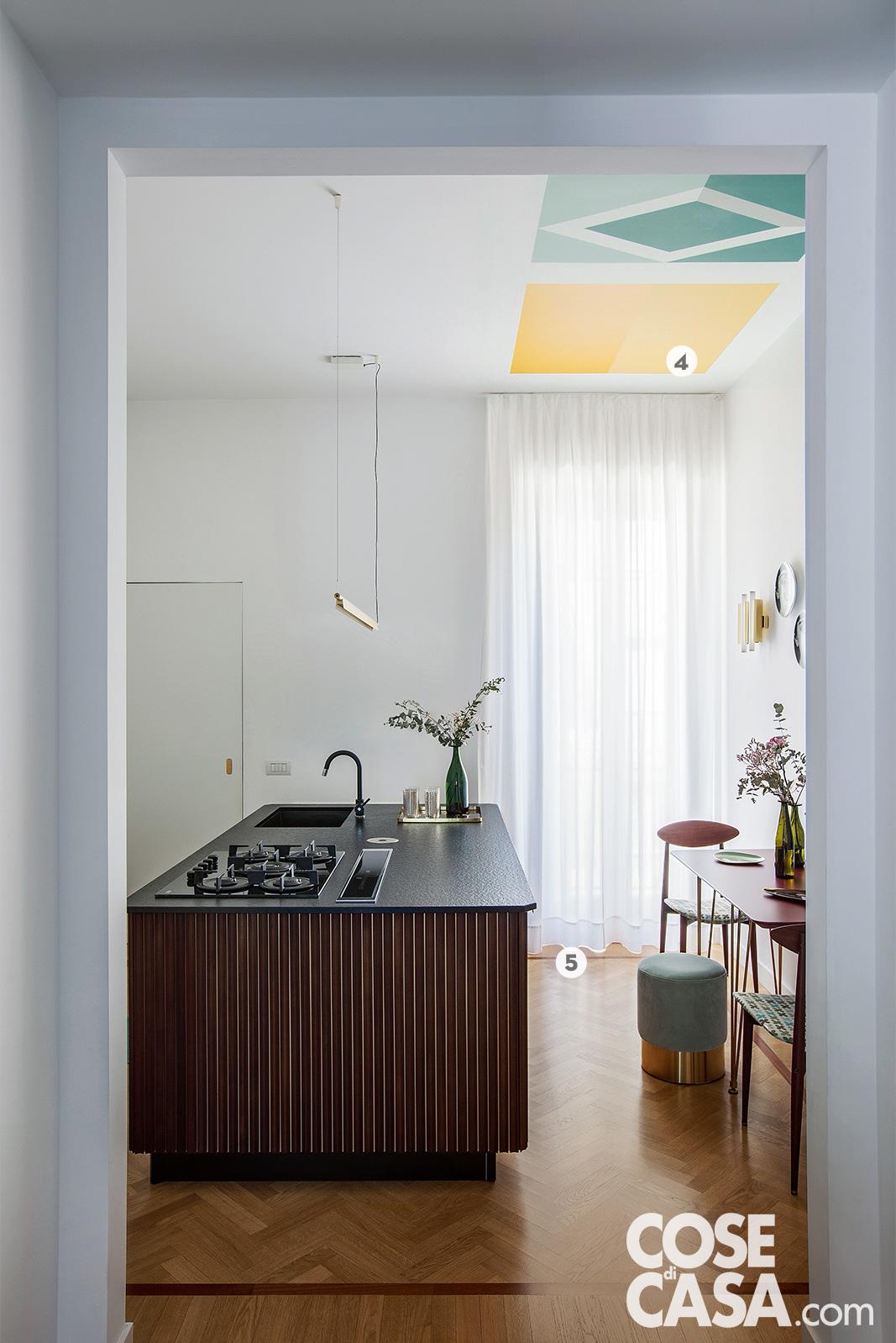 Elemento a isola nella cucina con rivestimento in listelli di legno tinta mogano effetto cannettato Elemento a isola nella cucina con rivestimento in listelli di legno tinta mogano effetto cannettato