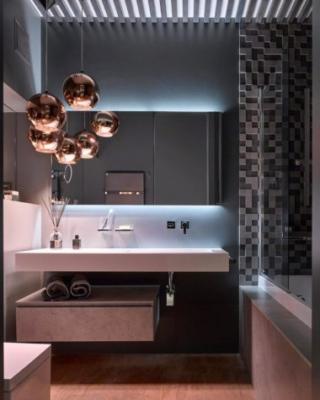 Lampada a sospensione di Tom Dixon; il bagno è la Collezione Cubik di Ideagroup