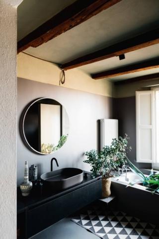 Bagno nero su pareti in resina vellutata. La tenue tonalità di beige alle pareti – valorizzata dall’effetto soft touch della resina – mette  in luce il carattere degli arredi neri. E non manca il tocco green. Bagno nero su pareti in resina vellutata. La tenue tonalità di beige alle pareti – valorizzata dall’effetto soft touch della resina – mette  in luce il carattere degli arredi neri. E non manca il tocco green.