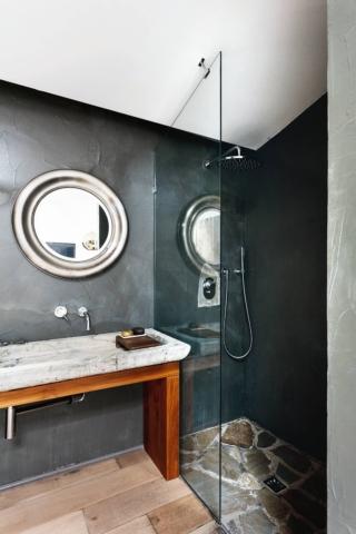 Piatto doccia in pietra opus incertum e resina scura a parete. Mix creativo. Le pietre formano il piatto doccia filo pavimento; la vasca di recupero in marmo diventa lavabo. Tocco finale, la resina scura spatolata a muro. Piatto doccia in pietra opus incertum e resina scura a parete. Mix creativo. Le pietre formano il piatto doccia filo pavimento; la vasca di recupero in marmo diventa lavabo. Tocco finale, la resina scura spatolata a muro.