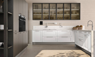 Una pratica forma a golfo per la cucina Agnese di Lube che è caratterizzata da basi con ante a telaio nella finitura bianco assoluto; le colonne, che danno vita ad una grande armadiatura che contiene i due forni, hanno le ante lisce in laccato bronzo brunito. A parete trovano posto i pensili con il telaio  in alluminio verniciato nero e i vetri bronzo. Un modulo base da 60 cm con due cestoni escluso top, prezzo 375 euro + IVA. www.cucinelube.it Una pratica forma a golfo per la cucina Agnese di Lube che è caratterizzata da basi con ante a telaio nella finitura bianco assoluto; le colonne, che danno vita ad una grande armadiatura che contiene i due forni, hanno le ante lisce in laccato bronzo brunito. A parete trovano posto i pensili con il telaio  in alluminio verniciato nero e i vetri bronzo. Un modulo base da 60 cm con due cestoni escluso top, prezzo 375 euro + IVA. www.cucinelube.it