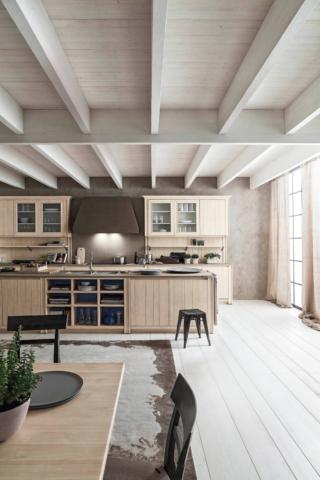 La cucina Maestrale di Scandola, interamente in abete massiccio, ha le ante dogate con apertura a gola in finitura bianco perla. Il top è in Ecocemento Fumo. www.scandolamobili.it