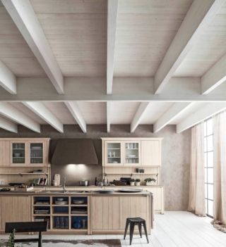 La cucina Maestrale di Scandola, interamente in abete massiccio, ha le ante dogate con apertura a gola in finitura bianco perla. Il top è in Ecocemento Fumo. www.scandolamobili.it