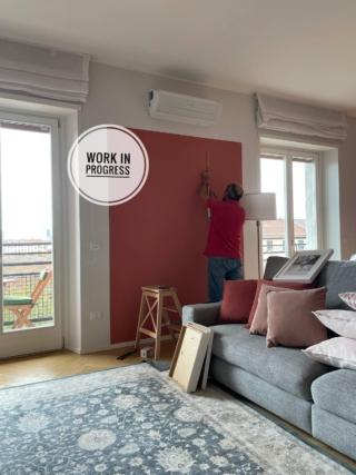 soggiorno con imbianchino che pittura un riquadro colorato tra le finestre