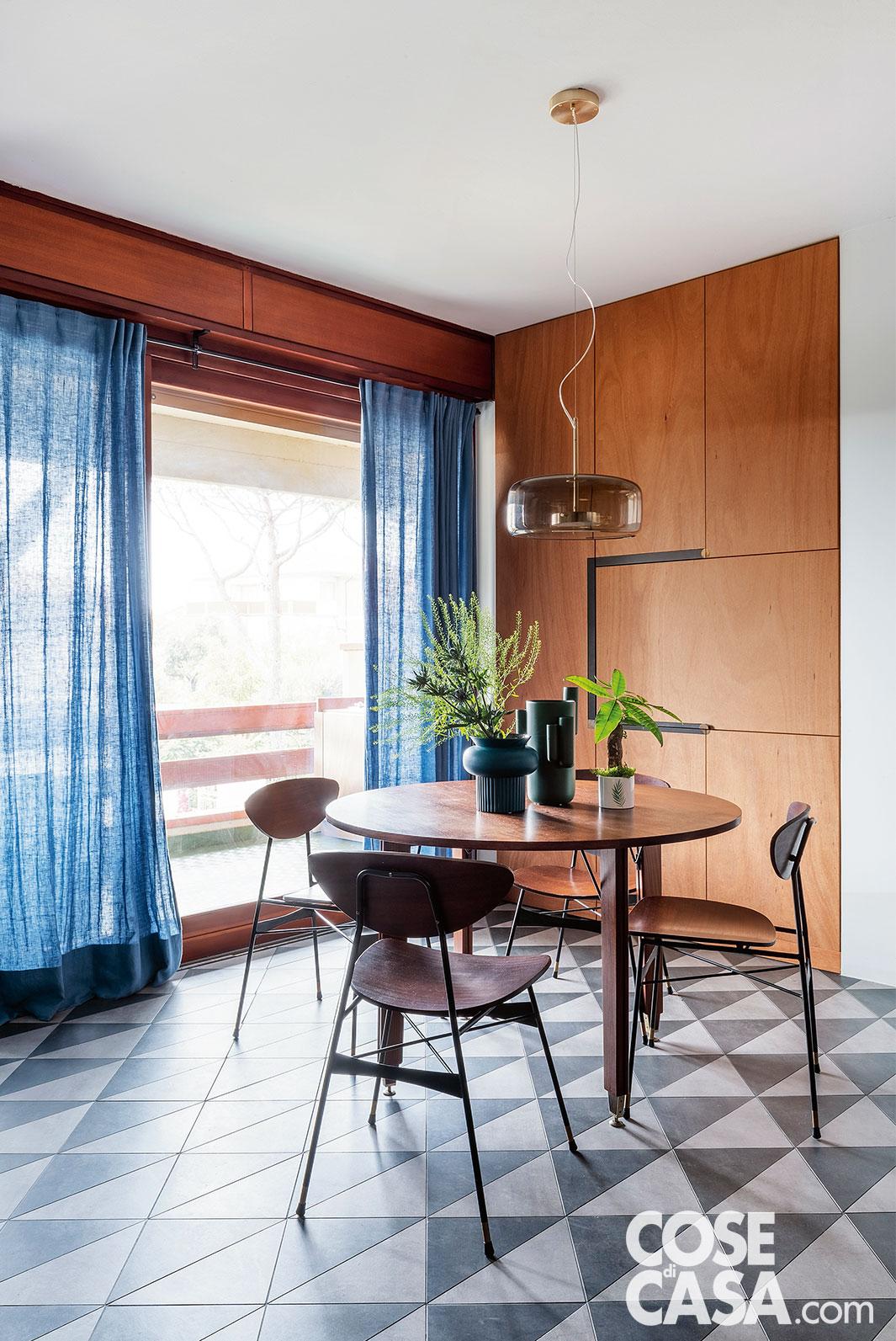 Nella zona pranzo, illuminata dalla vetrata, il tavolo rotondo e le sedie in legno sono modelli vintage, restaurati su progetto; il piano è illuminato dalla sospensione in policarbonato fumé Jube di Vistosi. I vasi appoggiati sono di Calligaris. Sulla parete di fondo, l'armadiatura a tutt'altezza è su disegno in multistrato di okumé (realizzata da La Falegnameria). I tendaggi sono in tessuto di lino blu semitrasparente. Le piante in vaso sono della Fioreria LelloFiori. Nella zona pranzo, illuminata dalla vetrata, il tavolo rotondo e le sedie in legno sono modelli vintage, restaurati su progetto; il piano è illuminato dalla sospensione in policarbonato fumé Jube di Vistosi. I vasi appoggiati sono di Calligaris. Sulla parete di fondo, l'armadiatura a tutt'altezza è su disegno in multistrato di okumé (realizzata da La Falegnameria). I tendaggi sono in tessuto di lino blu semitrasparente. Le piante in vaso sono della Fioreria LelloFiori.