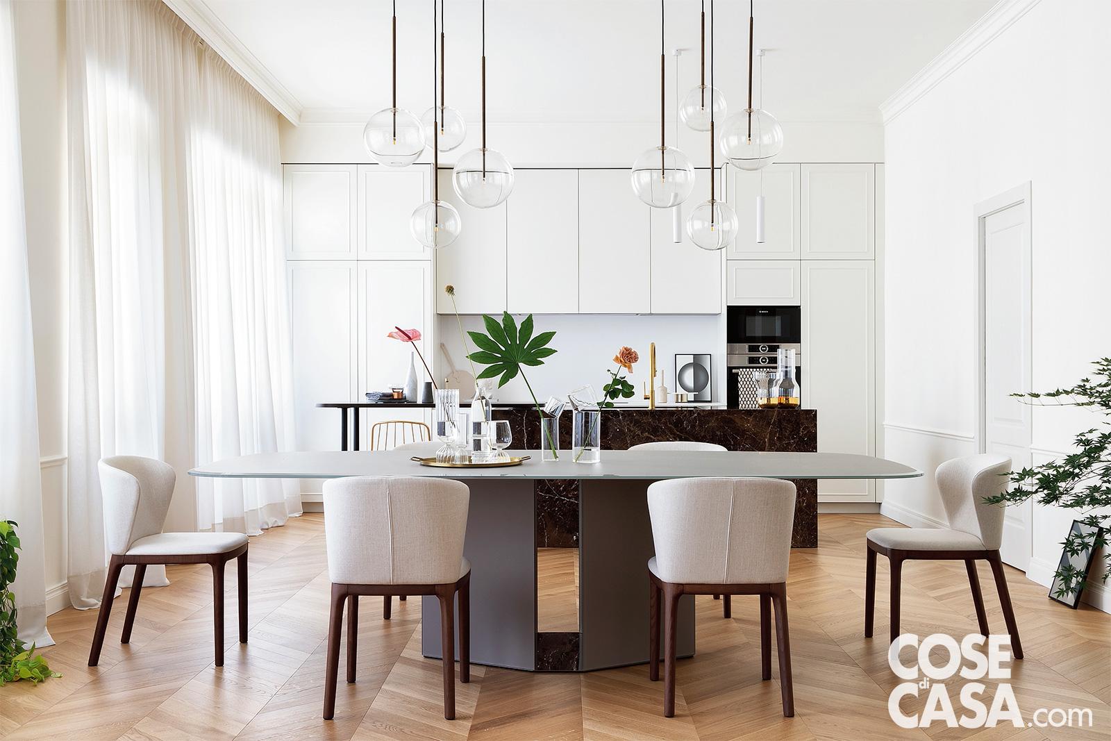 tavolo da pranzo con cucina bianca sullo sfondo