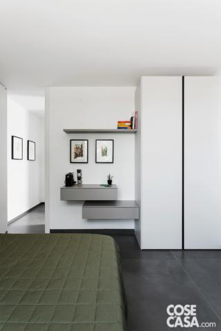 camera da letto con armadio bianco e contenitori sospesi