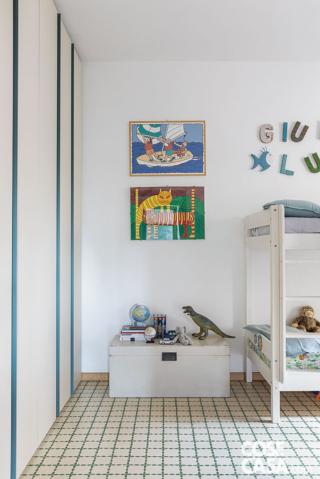 Nella camera dei ragazzi le cementine bianche con decoro verde sono originali della casa. Il letto a castello in laccato bianco con scaletta a pioli integrata nella struttura è di Jysk. Le lenzuola di Chez Moi. L'armadiatura a tutta parete è di Nardi Interni. La sospensione sferica in carta di riso è di Leroy Merlin. Le stampe incorniciate appese a parete di fianco al letto sono di Paolo Cardoni.