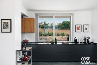 Nell'ambiente aperto, la zona operativa con il lavello e il piano cottura si concentra in uno spazio ribassato dal controsoffitto in cartongesso. Oltre a definire quest'area quasi come una stanza a se stante, il volume tecnico ha permesso di alloggiare la macchina motocondensante dell'impianto di climatizzazione/riscaldamento canalizzato.