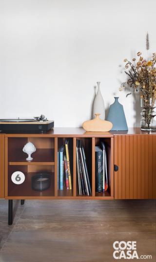 dettaglio della madia in soggiorno, vani aperti, anta cannettata, giradischi, vasi