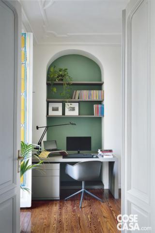 Nella zona studio in nicchia, la parete è stata tinteggiata con pittura verde di Sikkens. La sedia girevole in finitura grigio scuro è Fiber di Muuto; scrivania, cassettiera e mensole sono state realizzate su disegno e rivestire in Fenix® grigio. La lampada da tavolo nera orientabile è Tizio di Artemide, design Richard Sapper.