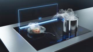 Tramite wi-fi, la cappa aspirante da piano iQ 700 glassdraftAir LD98WMM66 di Siemens è sintonizzata con il piano cottura. I due elettrodomestici, grazie ai sensori climateControl e cookConnect, misurano in automatico la quantità di fumi e odori nell’aria. Il vetro del piano si illumina con un fascio di luce led in nove tonalità. Funziona a 3 velocità + 2 stadi intensivi. Misura L 91,2 x P 14 x H 70,9/95,9 cm e costa, Iva esclusa, 3.227 euro.