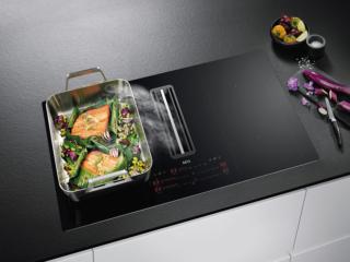 Nel piano a induzione ComboHob CDE 84773 CB di AEG è inserita la cappa centrale a scomparsa con portata max di 630 mc/h che adatta la velocità di aspirazione al tipo di cottura. Ha comandi elettronici SliderTouch e interfaccia singola per ciascuna delle 4 zone e la cappa. Grazie alla doppia funzione FlexiBridge si possono collegare due zone attigue. Funziona con connettività integrata e app My AEG Kitchen. Misura L 83 x P 51,5 cm. Prezzo su richiesta.   www.aeg.it