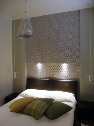 letto matrimoniale in nicchia con tappezzeria dietro