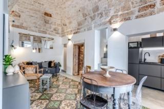 soggiorno pranzo cucina in nicchia con cementine e soffitto volta