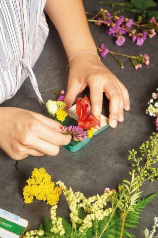 2. Accorciare lo stelo del Lisianthus e separare i fiori, lasciando a ognuno un gambo di circa 3 cm. Inserire per primo il bocciolo, ponendolo su un lato. 