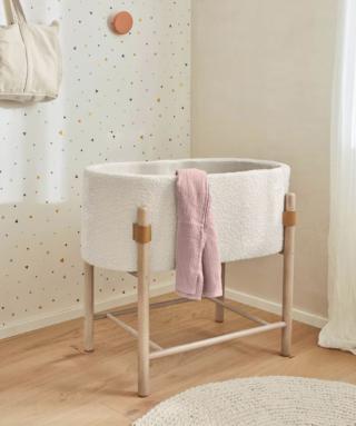 Accoglie il neonato come un morbido nido la culla Adara di Kave Home che è composta da una cesta in tessuto Shearling effetto lana bianca e da un telaio in legno massello di faggio certificato PEFC per la sua origine in foreste sostenibili e disboscamento controllato. Misura L 80 x P 46 x H 69 cm. Prezzo 240 euro. www.kavehome.com