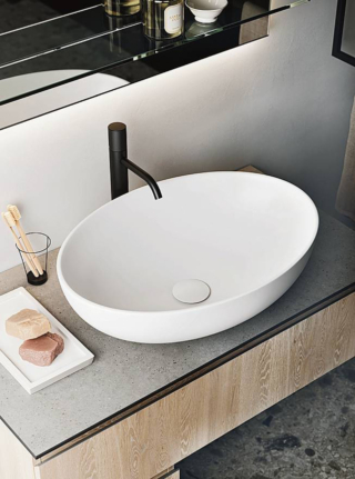 Forma ovale per il lavabo da appoggio Soffice Out di Arbi Arredobagno, realizzato in ceramica bianca opaca, con la piletta in tinta È disponibile anche colorato: Amazzonia, Curry, Denim, Fard. Misura
L 59,5 x P 42 x H 17 cm. www.arbiarredobagno.it