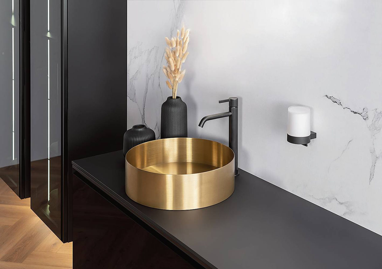 Dona un tocco prezioso al bagno il lavabo Neoro N40, realizzato in acciaio inox con finitura oro spazzolato e bordo sottile, di spessore 2,5 mm. È disponibile anche
in versione oro con bordo nero alla base. Ha diametro 40 x
H 12 cm. Oro costa 265,68 euro. In vendita da Reuter, www.reuter.com/it-it