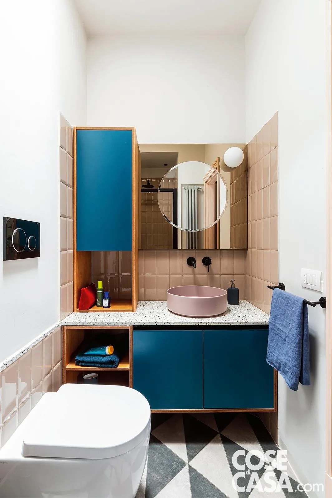 In questo piccolo bagno con lavabo e piastrelle rettangolari rosa, la posa in verticale slancia lo spazio e con altezze variabili protegge le zone "sensibili" vicino al lavabo e dietro ai sanitari. A contrasto il mobile blu e il nero di alcuni dettagli e del pavimento. In questo piccolo bagno con lavabo e piastrelle rettangolari rosa, la posa in verticale slancia lo spazio e con altezze variabili protegge le zone "sensibili" vicino al lavabo e dietro ai sanitari. A contrasto il mobile blu e il nero di alcuni dettagli e del pavimento.