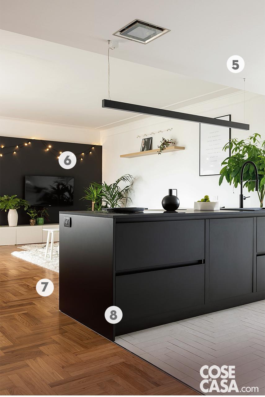 Sopra l'isola della cucina, la cappa quadrata in acciaio inox satinato e vetro incassata nel controsoffitto è il modello Modular di Foster da 36 cm. La lampada a sospensione con tiranti in acciaio è di Lucifero's. Appoggiata sul piano, la ciotola bianca con la frutta è di Paola C.